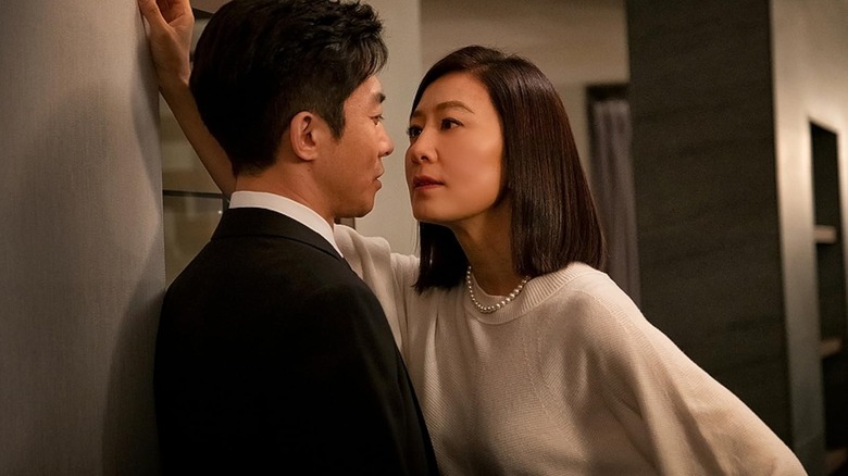 Ji Sun-woo (Kim Hee-ae) leans in to kiss Son Je-hyuk (Kim Young-min) in The World of the Married