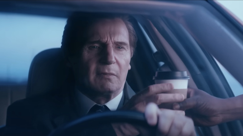 Frank Drebin Jr. (Liam Neeson) takes a coffee from a random hand outside of his moving car in The Naked Gun