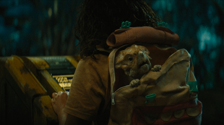 Audrina Miranda as Isabella Delgado carrying around a baby dinosaur named Dolores in her backpack in Jurassic World Rebirth