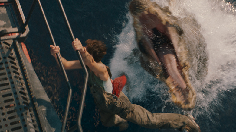 Philippine Velge as Nina clinging to the side of a boat as a Spinosaurus attacks from the water in Jurassic World Rebirth