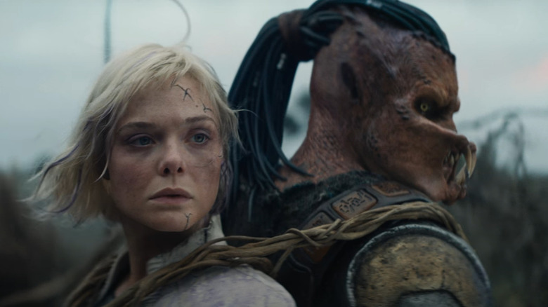 Elle Fanning as Thia riding on the back of the young Predator in Predator: Badlands