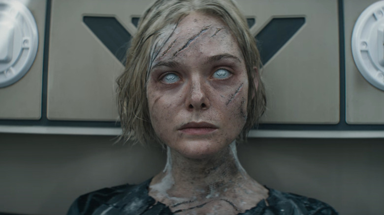 Elle Fanning as Thia sitting in a chamber beat up from battle in Predator: Badlands