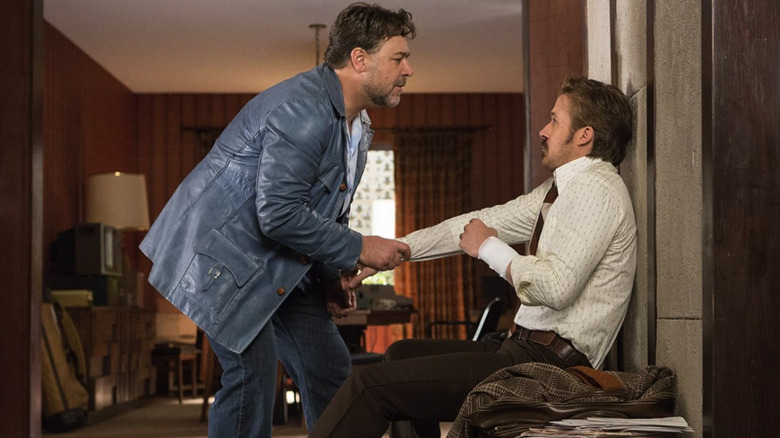 Jackson Healy leans threateningly toward a seated Holland March in The Nice Guys