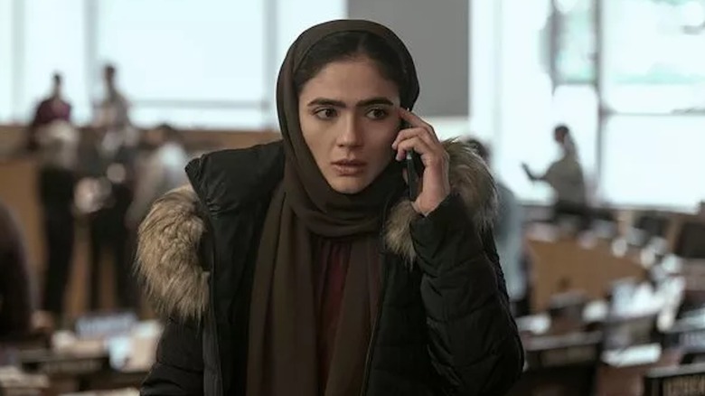 Arienne Mandi takes an urgent phone call as Noor Taheri in The Night Agent