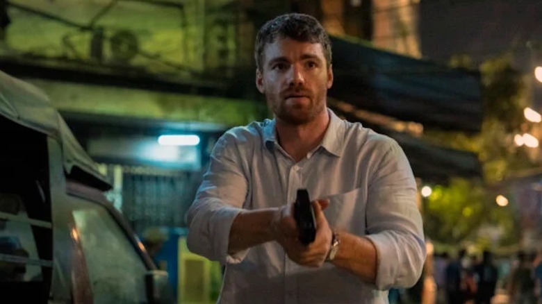 Phoenix Raei brandishes a handgun as Dale in The Night Agent