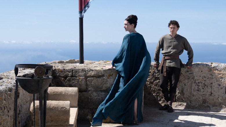 Penelope and Telemachus stand on top of the palace in The Odyssey