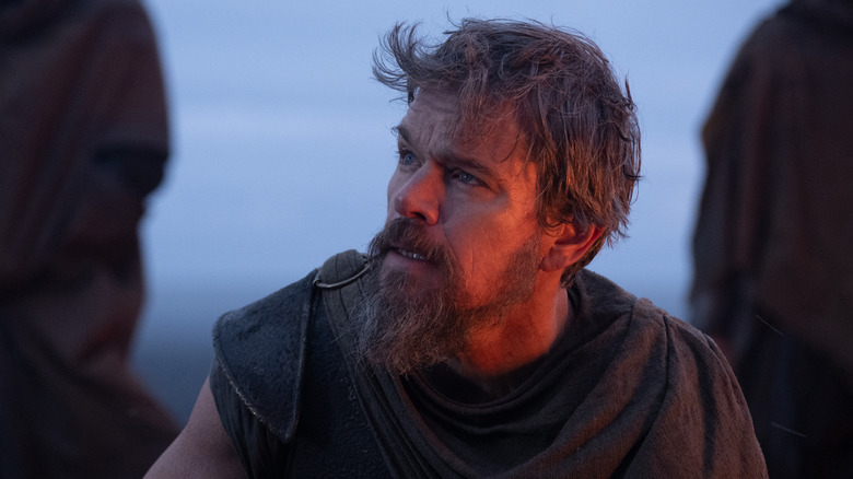 Matt Damon as Odysseus lit by an orange glow in The Odyssey (2026)