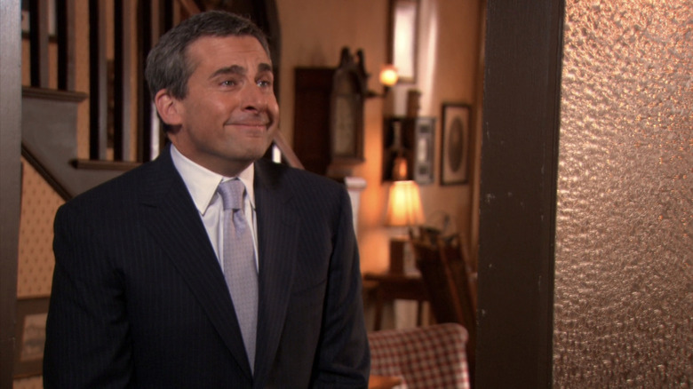 Steve Carell's Michael Scott stands in a suit as he surprises Dwight at his wedding in The Office