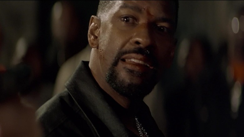 Denzel Washington's Alonzo Harris looks scared in front of a gun held by someone behind the camera on Training Day
