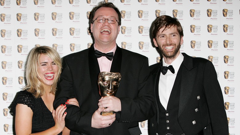 Billie Piper, Russell T. Davies, and David Tennant smiling