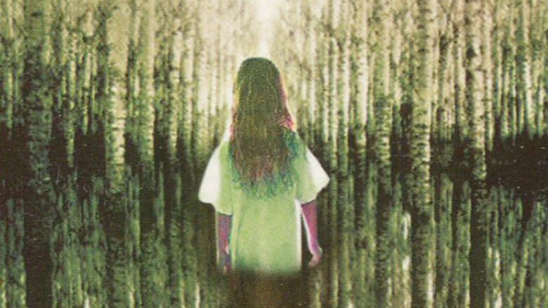 Trisha walking through the woods on the cover of The Girl Who Loved Tom Gordon