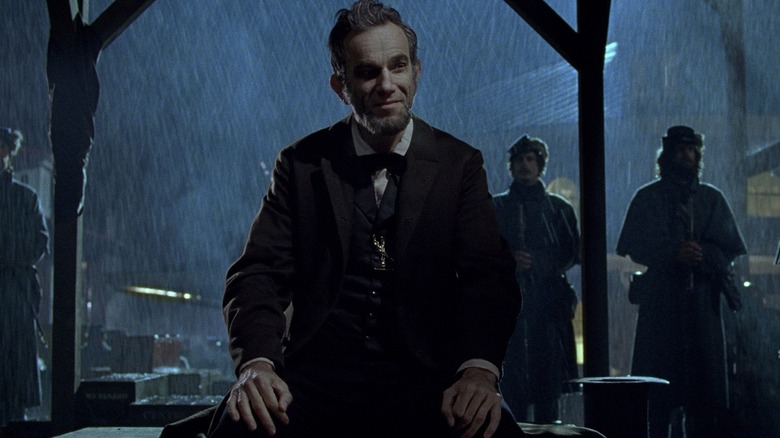 Daniel Day Lewis as Abraham Lincoln sitting in the rain in Lincoln