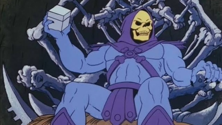 Skeletor sitting on his throne, holding a box in one hand in He-Man and the Masters of the Universe (1983)