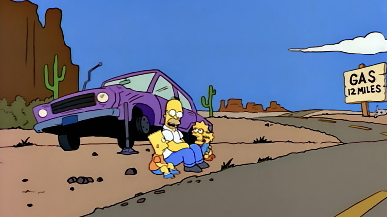 Homer Simpson est assis près de sa voiture dans le désert avec Lisa et Bart Simpson dans Les Simpsons