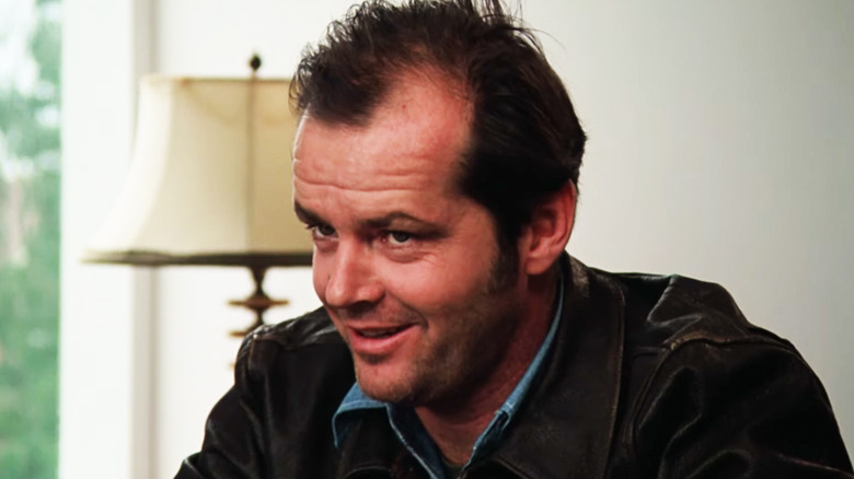 Jack Nicholson's Randle Patrick McMurphy smiles as he sits in an office in One Flew Over the Cuckoo's Nest