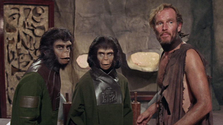 ప్లానెట్ ఆఫ్ ఏప్స్ (1968)లో కార్నెలియస్, జిరా మరియు జార్జ్ టేలర్ కలిసి నిలబడి ఉన్నారు