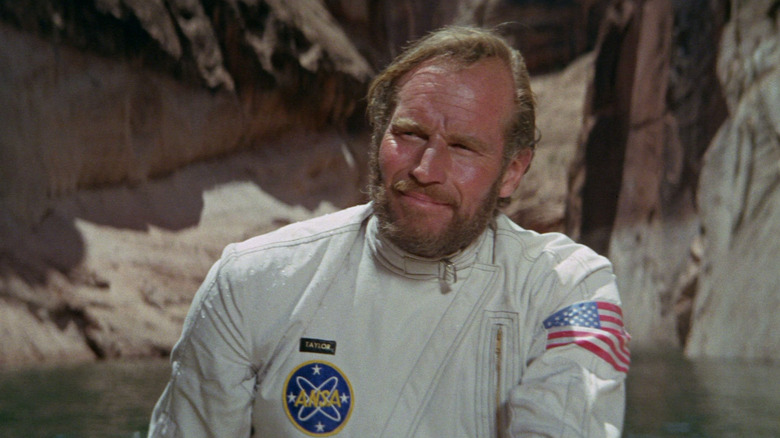 George Taylor wearing his astronaut suit next to a lake in Planet of the Apes (1968)