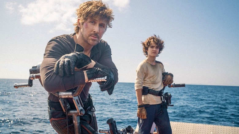 Ryan Gosling and Flynn Gray next to an ocean on the set of Star Wars: Starfighter