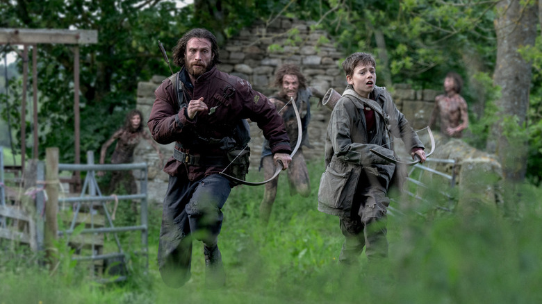 Aaron Taylor-Johnson as Jamie and Alfie Williams as his son Spike running away from infected in 28 Years Later