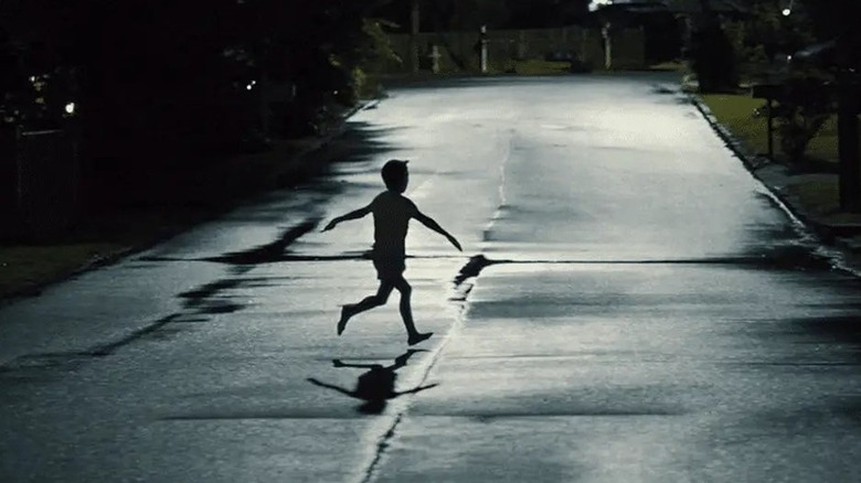 A kid running through the road with his arms held out in Weapons