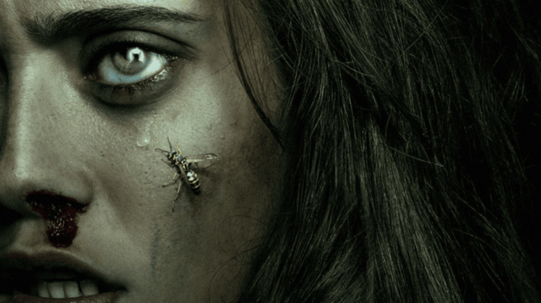 Jackie with a bloody nose, a yellowjacket on her cheek, and the Antler Queen reflected in her eye in the Yellowjackets poster