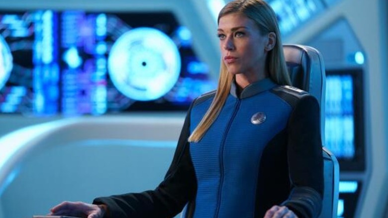Adrianne Palicki's Commander Kelly Grayson sitting on a chair and wearing blue uniform on The Orville: New Horizons