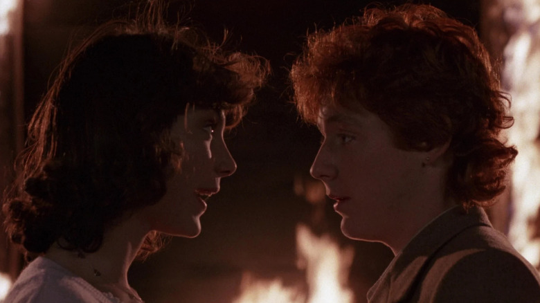 Megan and Brad talking in front of a burning barn in Critters 2: The Main Course
