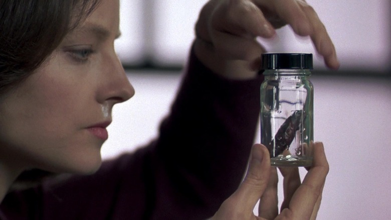 Jodie Foster's Clarice Starling holds up crime scene evidence in The Silence of the Lambs