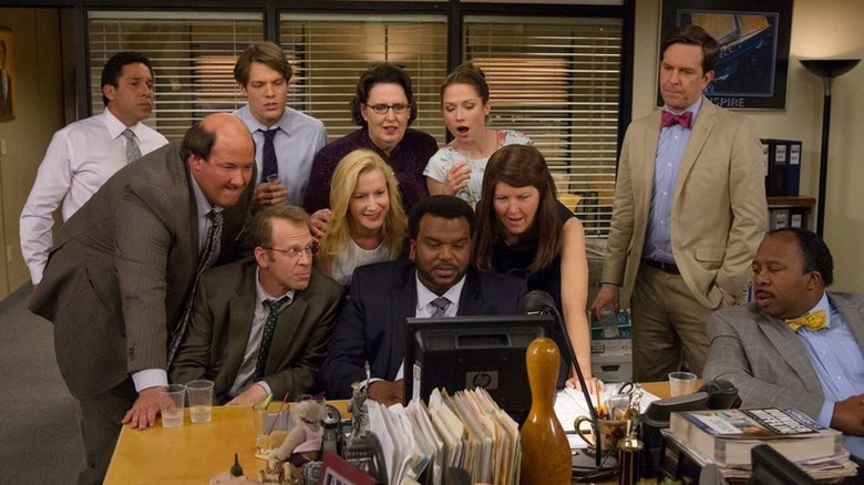 Dunder Mifflin's employees gathered around a computer on "The Office"