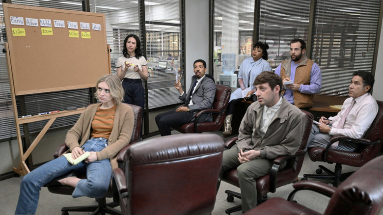 The ensemble cast of The Paper in a meeting in the conference room