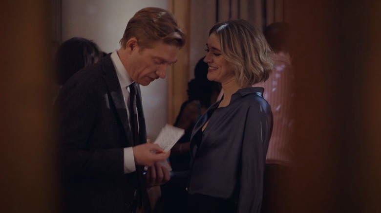 Mare laughing at Ned as he reads cards