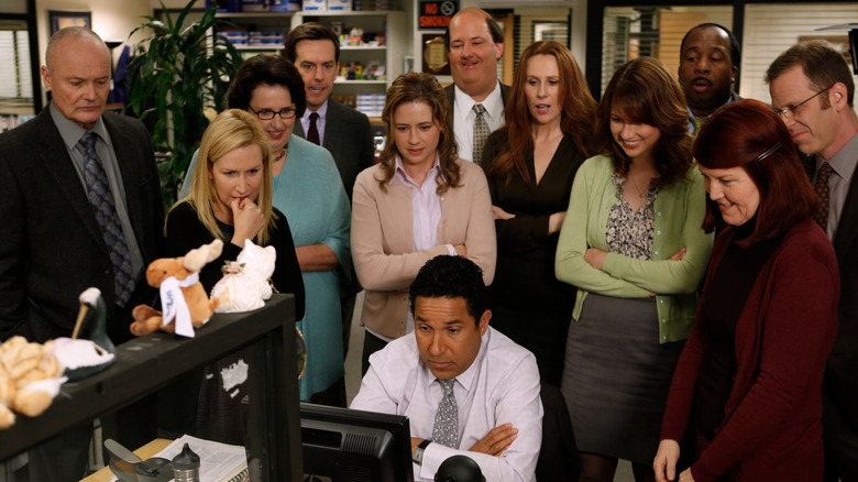 The cast of The Office looking at Oscar's computer screen