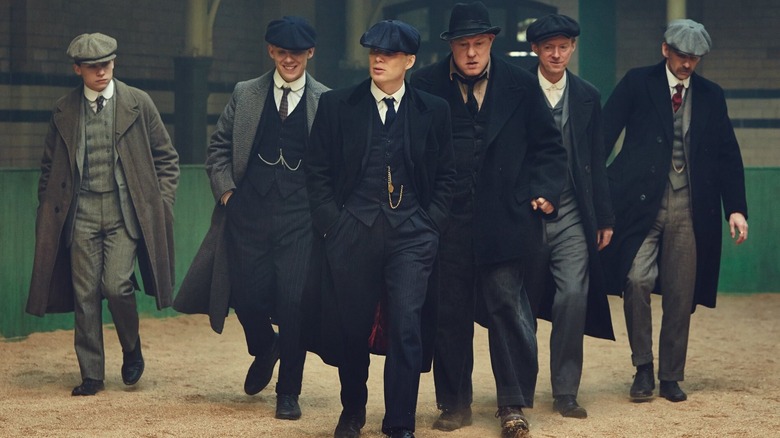 Cillian Murphy as Tommy Shelby, Paul Anderson as Arthur Shelby, Finn Cole as Michael Gray, and other members of the Shelby gang walking imposingly in Peaky Blinders
