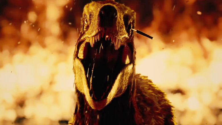 A raptor surrounded by fire with a knife in its eye in Primtive War