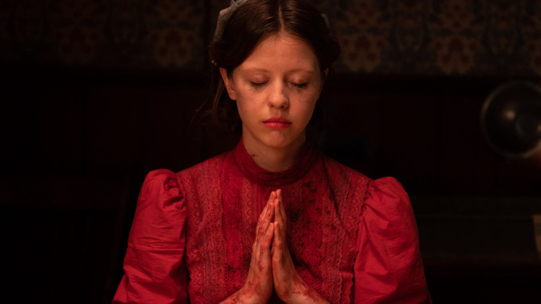 Mia Goth praying in Pearl