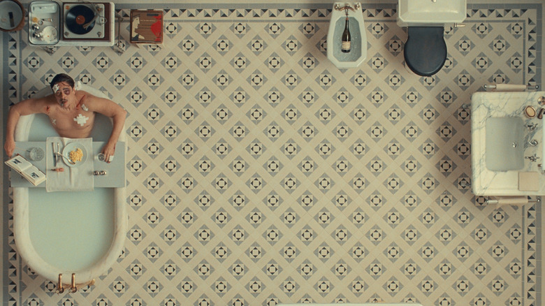 An overhead shot of Benicio del Toro as Zsa-Zsa Korda taking a bath in The Phoenician Scheme