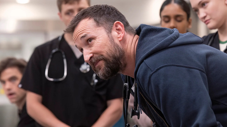 Noah Wyle as Dr. Robby on The Pitt, surrounded by residents and interns
