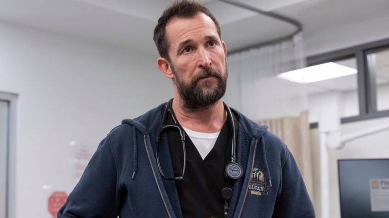Dr. Robby looking at something concerned in scrubs and a hoodie on The Pitt