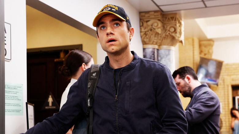 Patrick Ball's Frank Langdon stands in the ER wearing a cap in The Pitt