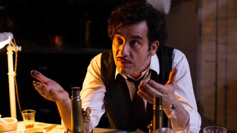 Clive Owen as Dr. John Thackery sitting at a desk on The Knick