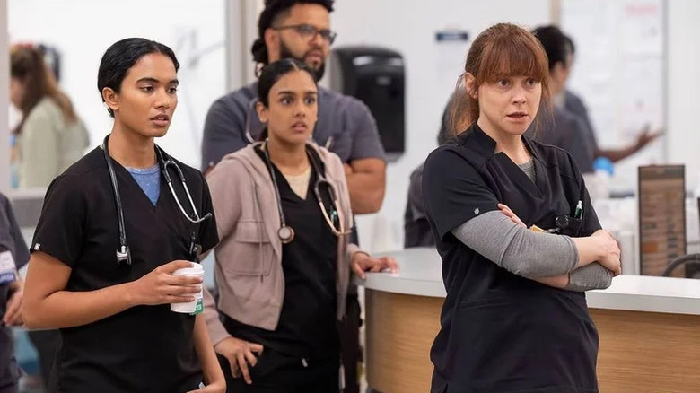 Supriya Ganesh as Dr Mohan, Shabana Azeez as Dr Victoria Javadi, and Fiona Dourif as Dr Cassie McKay stand together in the ER in The Pitt