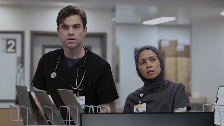 Langdon and Perlah looking surprised at the desk on The Pitt