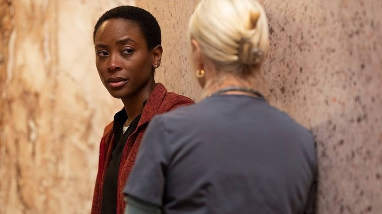 Collins with her eyebrow raised talking to Dana on The Pitt
