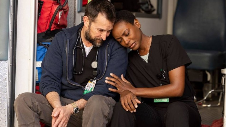 Collins leaning on Robby in the ambulance on The Pitt