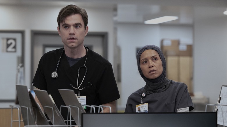 Langdon and Perlah looking surprised at the desk on The Pitt