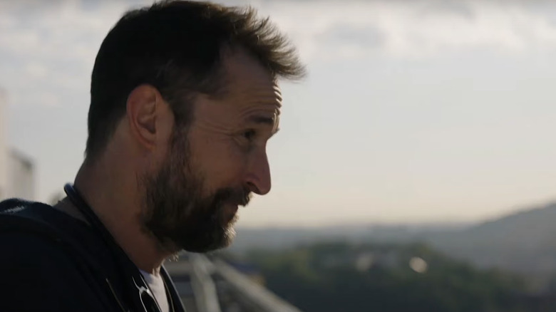 Noah Wyle's Dr Michael Robonavitch looks out from the roof of his hospital in The Pitt