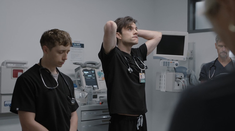 Gerran Howell's Dennis Whitaker stands next to Patrick Ball's Frank Langdon during a moment of silence in The Pitt