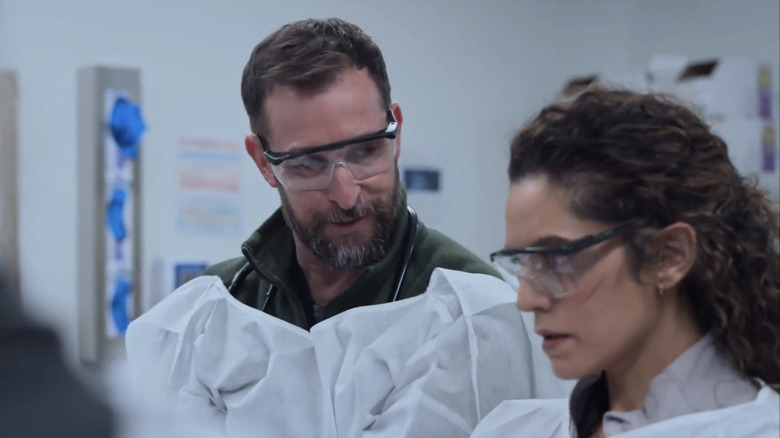 Noah Wyle's Dr. Michael Robinavitch watches Sepideh Moofi's Dr. Baraan Al-Hashimi as she observes a procedure in the Pitt emergency room