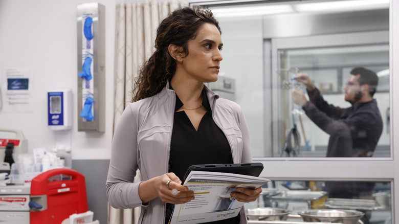 Dr. Baran Al-Hashimi  holds a tablet on The Pitt season 2