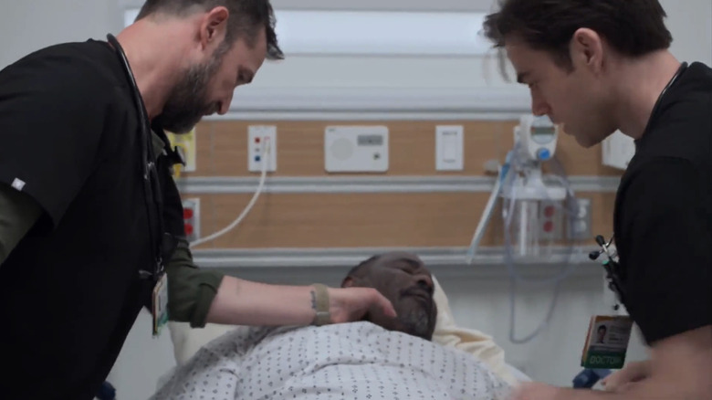 Noah Wyle's Dr Michael Robinavitch checks the pulse of Ernest Harden Jr.'s Louie Cloverfield as Patrick Ball's Dr Frank Langdon assists in The Pitt